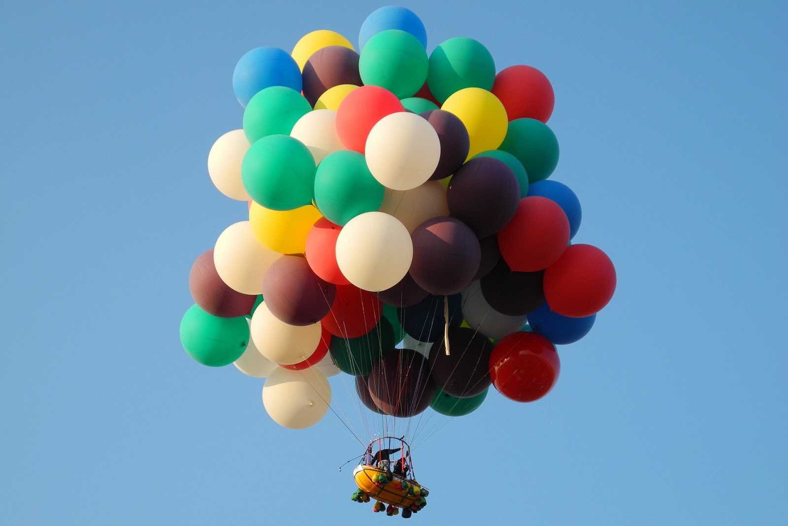 Barca llevada por el cielo con muchos globos
